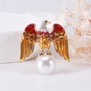 Vintage eagle brooch with enamel wings, white crystals, and a large pearl on white background