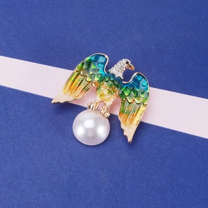 Detailed close-up of eagle brooch featuring gradient enamel wings and a large pearl