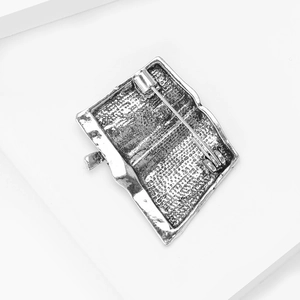 Detailed back view showing the vintage silver metal texture and pin clasp of book brooch