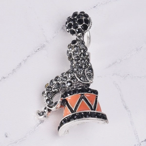 Detailed view of sea lion brooch with grey rhinestones and orange enamel circus drum
