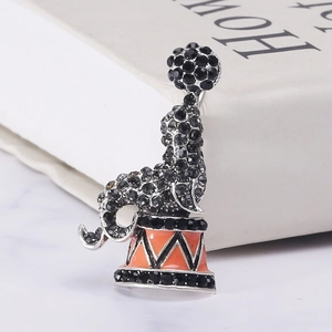 Detailed close-up of crystal-encrusted dolphin brooch with orange enamel circus base