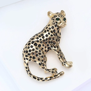 Golden leopard brooch with black enamel spots and green gemstone eyes for suits