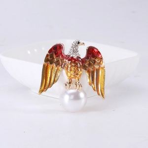 Detail of eagle brooch with enamel wings, rhinestone head, and round faux pearl