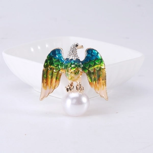 Detailed view of eagle brooch with colorful enamel wings and large white faux pearl