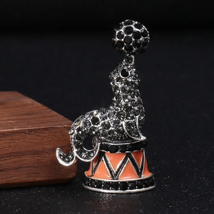 Macro detail of seal brooch featuring intricate grey rhinestones and orange circus base