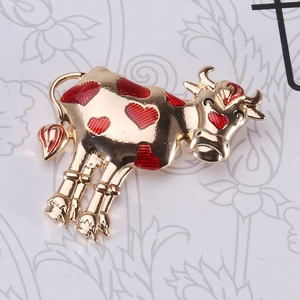 Detail showing creative ox brooch with golden enamel finish and red heart patterns