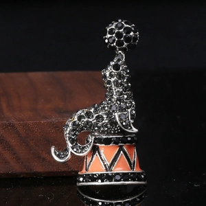 Detailed macro shot of a playful dolphin brooch with black rhinestones and enamel ball