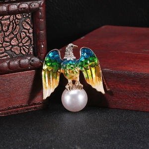 Detailed macro shot of vintage eagle brooch with gradient enamel and pearl accent