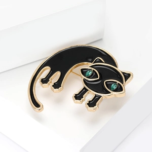Detail van zwarte emaille kattenbroche met groene edelsteenogen en gouden randen