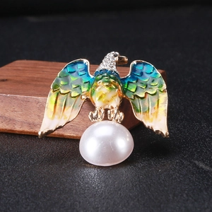 Detailed close-up of eagle brooch with enamel wings, crystal head, and large pearl