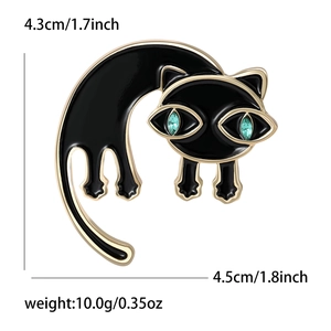 Zwarte emaille kattenbroche met groene strass ogen, strekkende houding, maat 4,5cm x 4,3cm