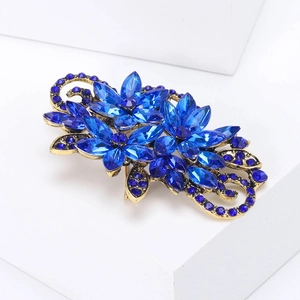 Close-up of vintage blue crystal flower brooch with marquise rhinestones and bronze base