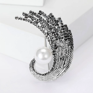 Close-up of vintage feather brooch with black crystals and a large white pearl center