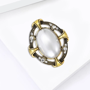 Broche baroque vintage avec perle et diamants sur cadre doré et socle blanc