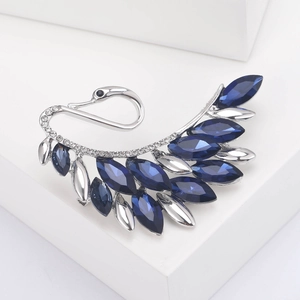 Detailed macro view of an elegant silver swan brooch with deep blue marquise-cut crystals