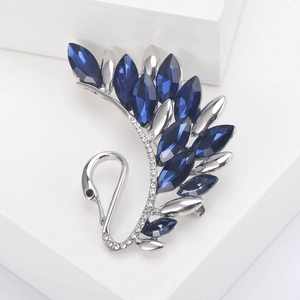 Detailed close-up of crystal swan brooch with navy blue marquise stones and silver plating