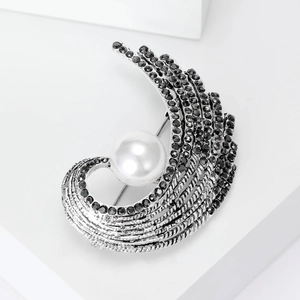 Vintage wing-shaped brooch with black rhinestones and pearl on white stand