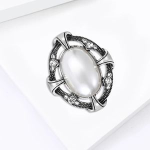 Détail de la broche vintage en argent avec fausse pierre de lune avec des cristaux étincelants
