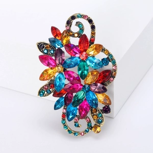 Macro shot of retro flower brooch with colorful rhinestones on an antique gold base