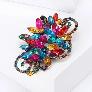 Detail of vintage bronze flower brooch with colorful marquise crystals and filigree