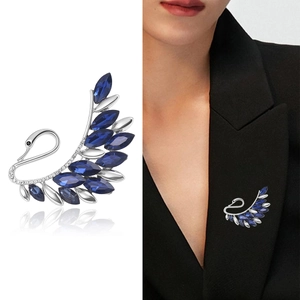 Elegant crystal swan brooch with royal blue gems on a classic black blazer lapel