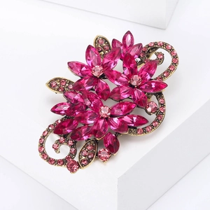 Detail of vintage flower brooch with pink crystals and antique gold metal setting