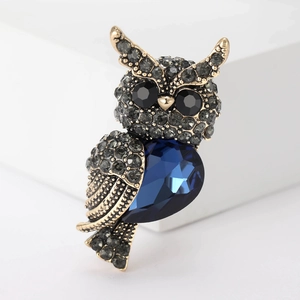 Vintage gold owl brooch with deep blue pear-shaped gemstone and grey rhinestone detailing