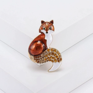 Detailed macro shot of an enamel fox brooch with sparkling rhinestones and golden base