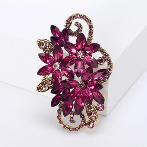 Retro floral brooch with purple crystals and gold alloy vines on a clean white display