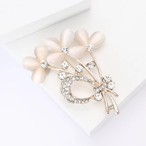 Broche bouquet dorée élégante avec pétales en opale et détails de nœud en strass brillants