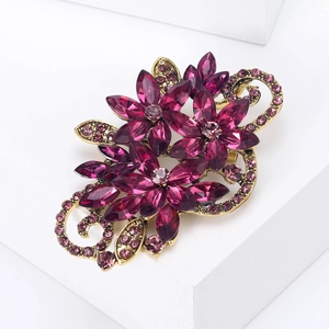 Detailed close-up of vintage gold flower brooch with purple marquise crystals