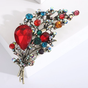 Vintage luxury flower bouquet brooch with multicolored crystals on a white pedestal