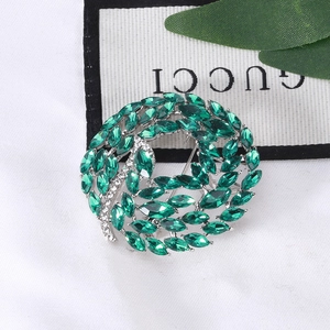 Detail of emerald crystal circular leaf brooch with silver alloy pin and tiny white diamonds