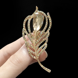 Macro shot of a gold leaf brooch featuring champagne pear-cut crystal and rainbow rhinestones