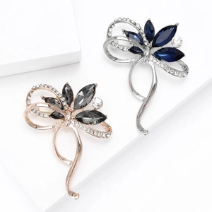 Broches élégantes en forme de ruban avec cristaux en rose doré et argent sur support blanc