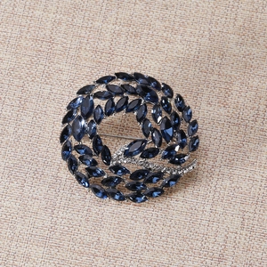 Macro detail of royal blue marquise crystal wreath brooch with silver pavé accents
