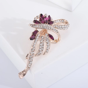 Détail de la broche fleur avec pierres marquises violettes et fini or rose poli
