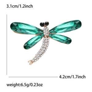 Detailed view of dragonfly brooch showing 4.2cm width and 3.1cm height with green crystals
