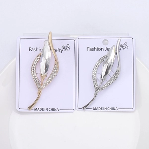 Détail macro de broches feuilles élégantes avec cristal marquise et strass pavés