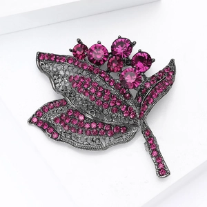 Détail de la broche vintage herbes avec strass magenta sur base en alliage noir