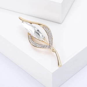 Détails de la broche fleur de lys dorée sertie de cristaux et de strass marquise brillants