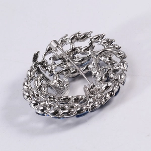 Elegant silver circle flower brooch with deep blue crystals and secure pin closure