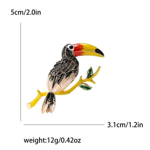 Détail de la broche toucan en émail montrant la hauteur de 5 cm et la texture des cristaux