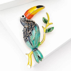 Gros plan détaillé de la broche toucan avec émail coloré et accents de cristaux bleus