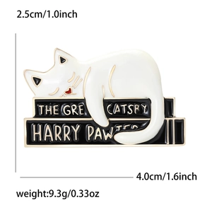 Detail view of cat enamel pin on books showing dimensions 4.0cm width and 2.5cm height