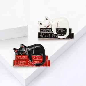 Cute enamel cat brooches on books featuring black and white lazy cats pins