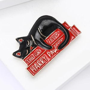 Cute black cat enamel pin lying on red books with literary puns Harry Pawter and Catspy