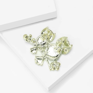 Detail of the golden alloy owl brooch back featuring dual metal safety pins for secure fastening