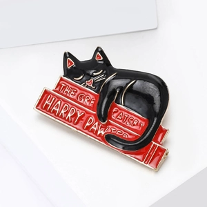 Creative enamel brooch featuring a black cat lying on red books with golden metal edges