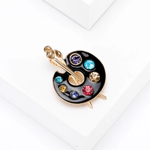 Artistic palette brooch with colorful rhinestones and gold brushes on white block